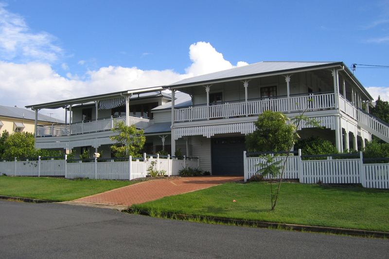 Raised white Queenslander house with verandahs and a tin roof in Brisbane